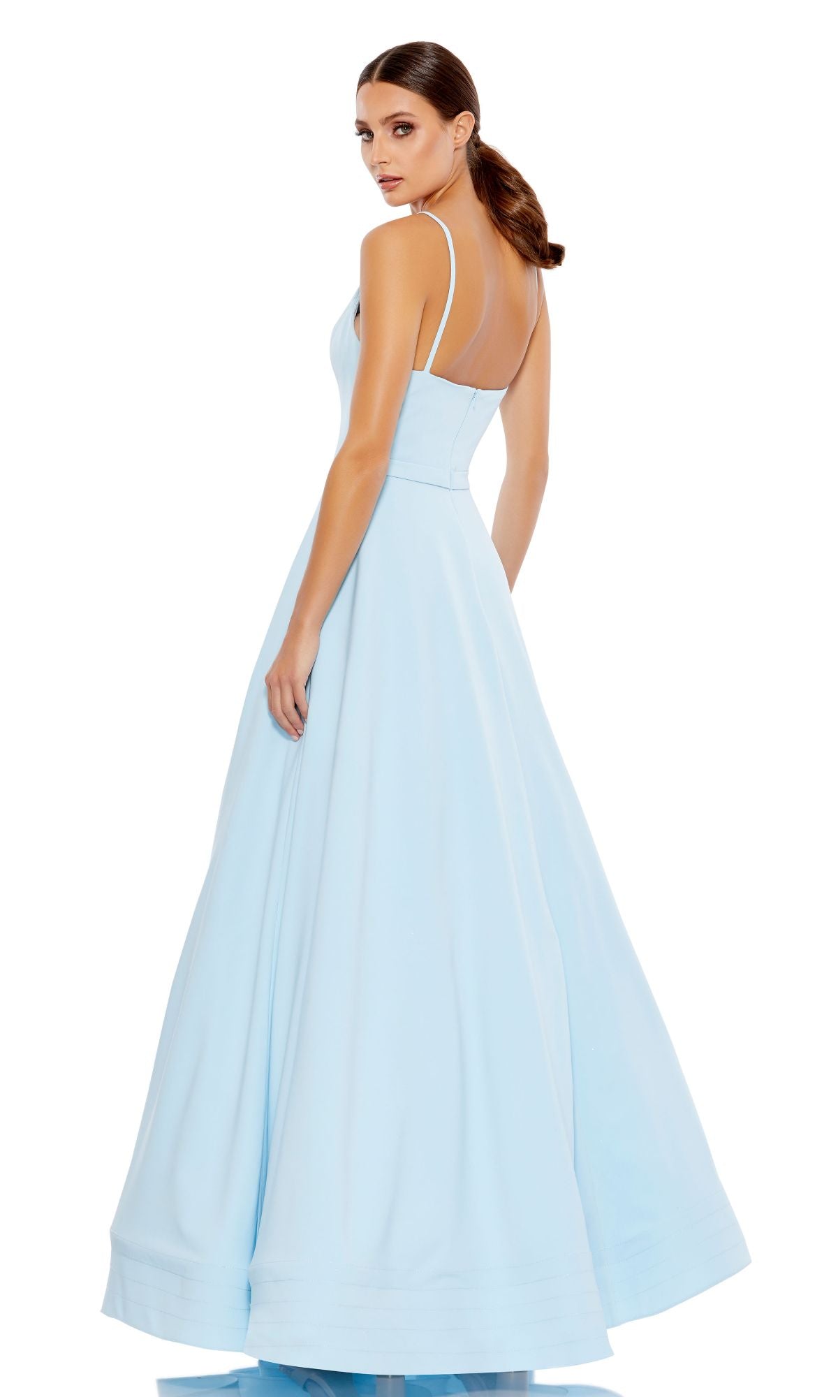 Woman wearing the Classic Long A-Line Formal Dress: Mac Duggal 48855, a light blue, floor-length gown with thin straps, standing and looking over her shoulder against a white background.